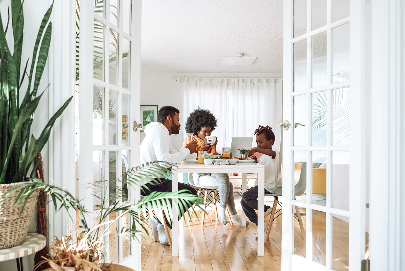 family of three eating a meal at a table in their house