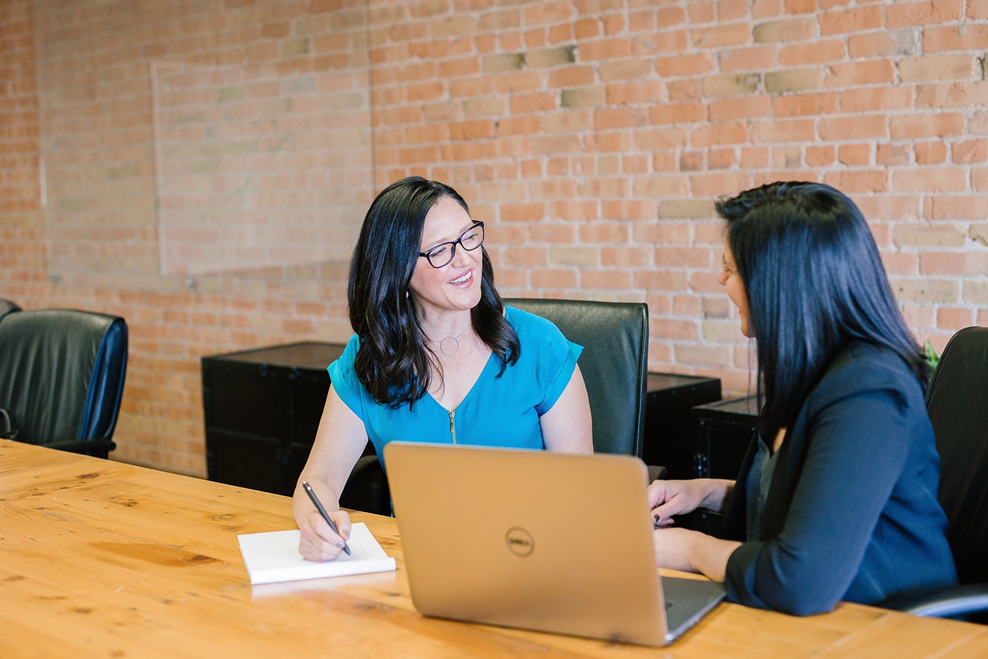 Women working on a laptop at a conference table