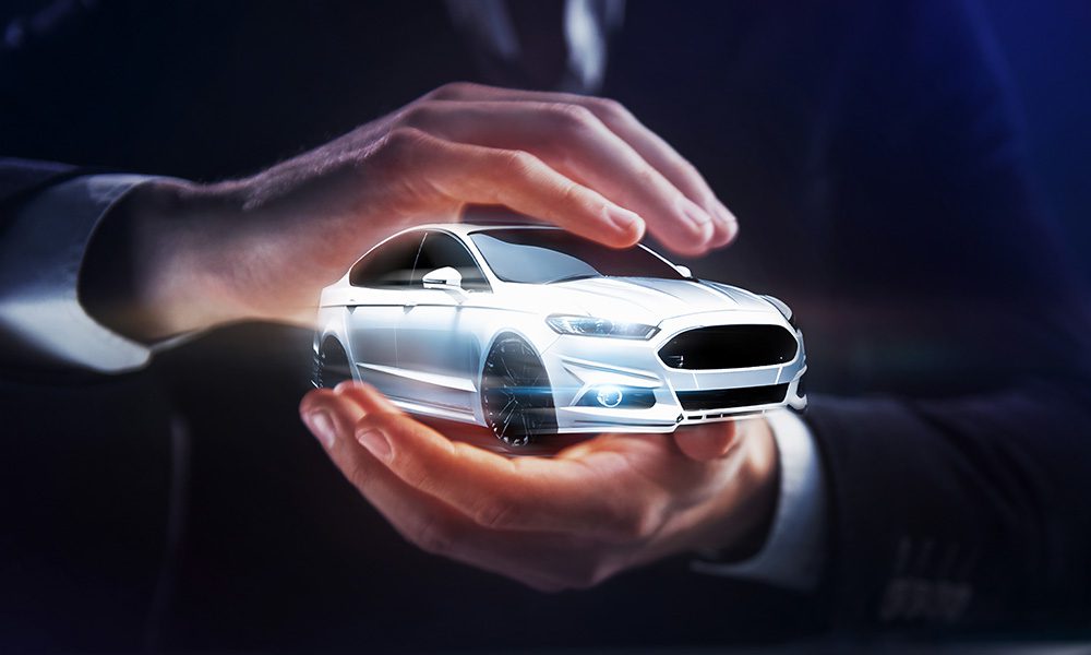 Blog-Closeup-View-of-a-Businessman-Holding-a-White-Sedan-Car-in-Between-his-Two-Hands
